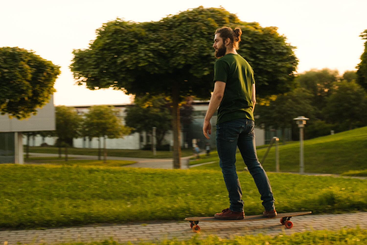 Typ in grünem T-Shirt fährt Longboard Typ in grünem T-Shirt fährt Longboard